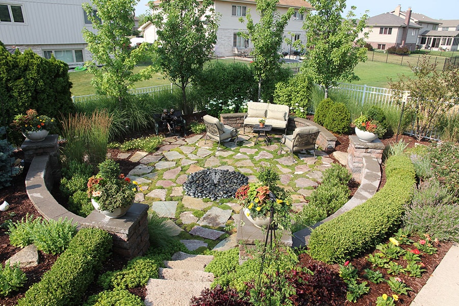 paver stone patio and shrubbery with stone retaining wall hardscape in Naperville Illinois