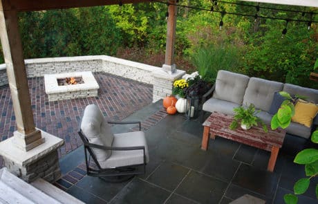 paver stone patio with fire pit, brick retaining wall, and custom pavilion done by bret-mar landscaping