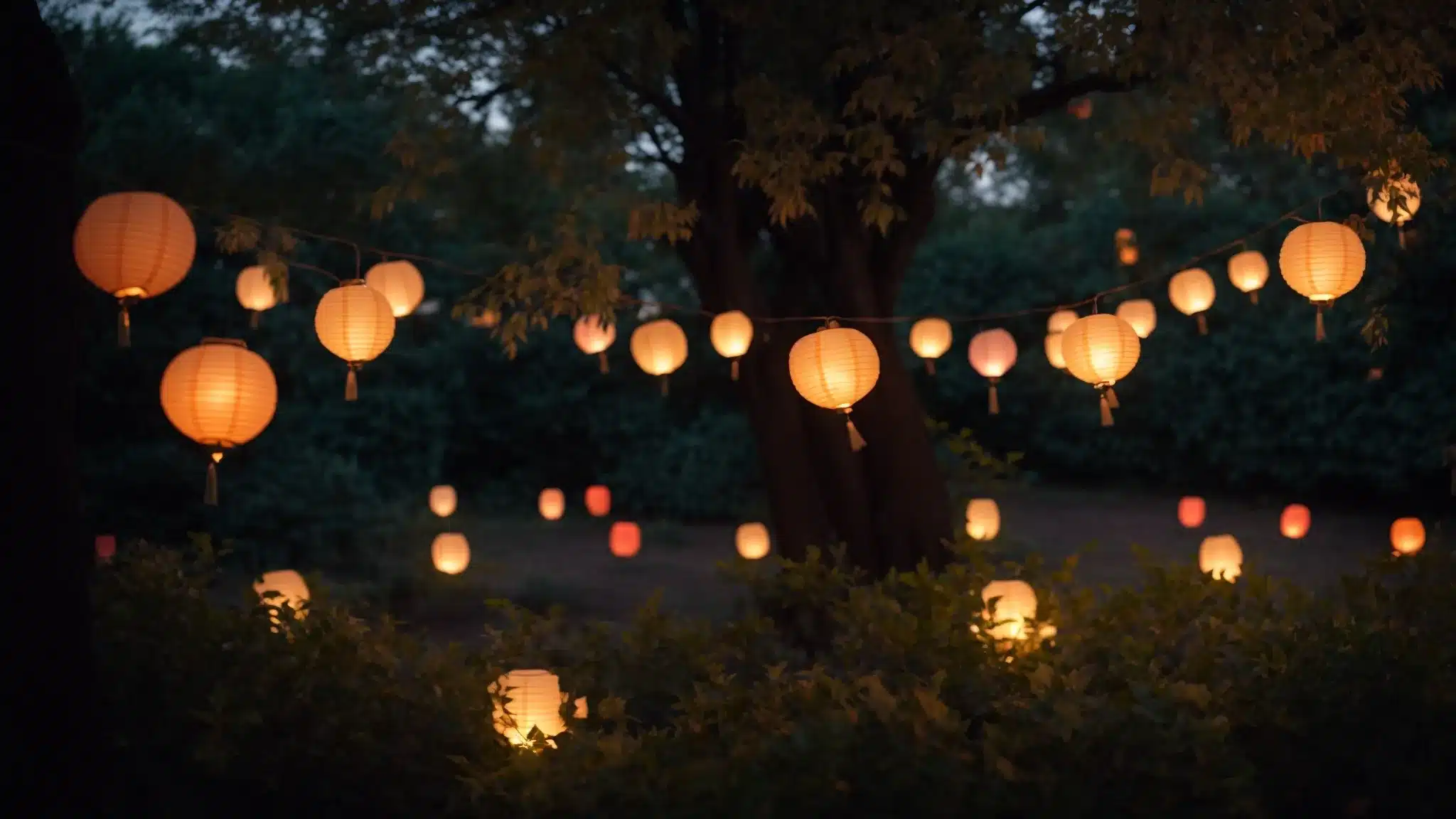 paper lanterns hang whimsically from a tree's branches, illuminating a garden with a soft, magical glow at dusk.