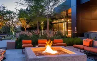 a stylish, modern outdoor living space showcases a newly installed fire pit, surrounded by sleek seating and vibrant decor, all under the warm glow of evening lights, emphasizing the ultimate backyard transformation.