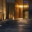 a modern driveway illuminated by sleek, decorative lighting fixtures casts a warm glow against a contemporary urban backdrop, emphasizing the elegance of architectural design learning.