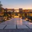 a modern, elegantly designed entryway showcases a stunning illuminated driveway, featuring sleek path lights and artistic landscaping that enhances the ambiance of the evening setting.